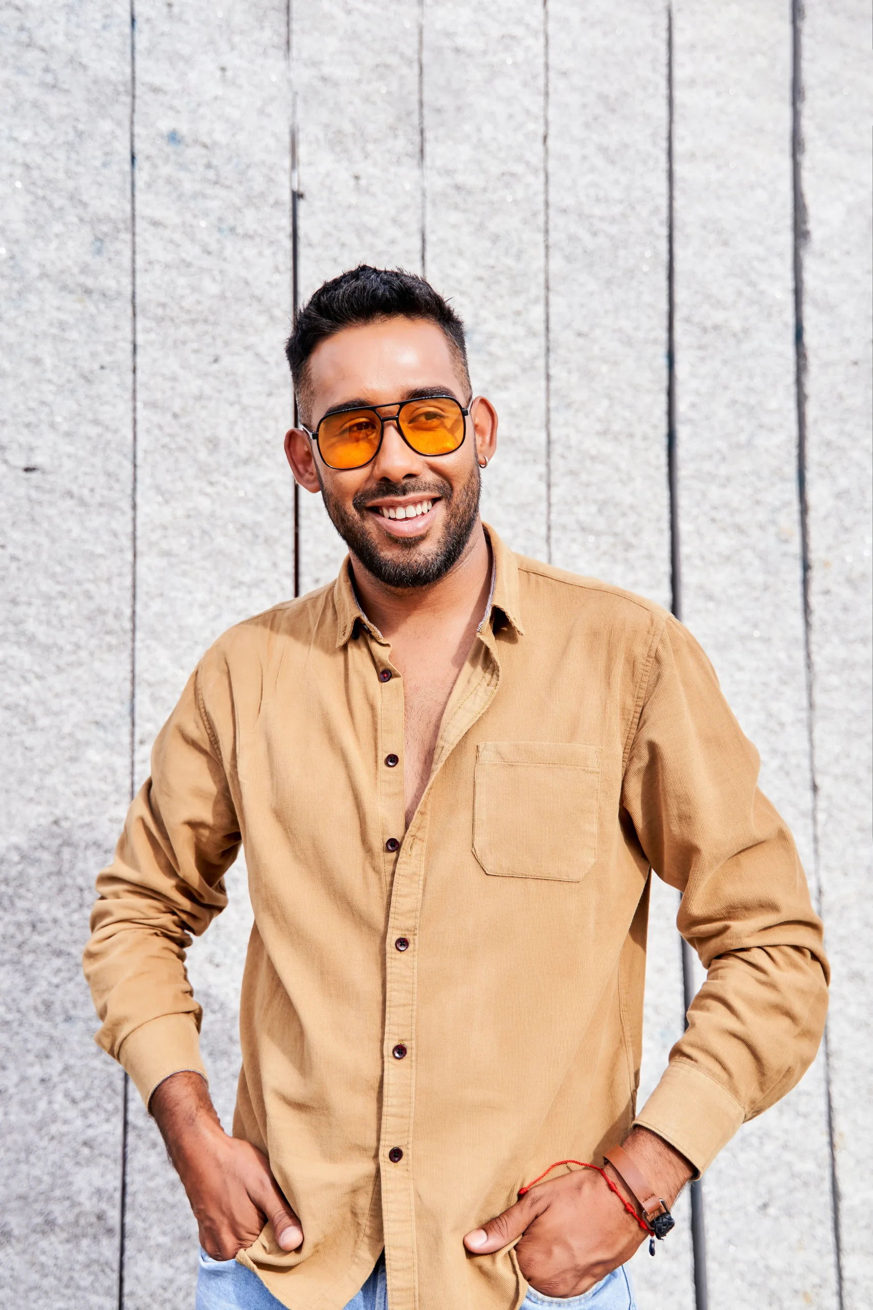 Creador digital sonriendo en sesión fotográfica, representando casos reales de crecimiento en OnlyFans