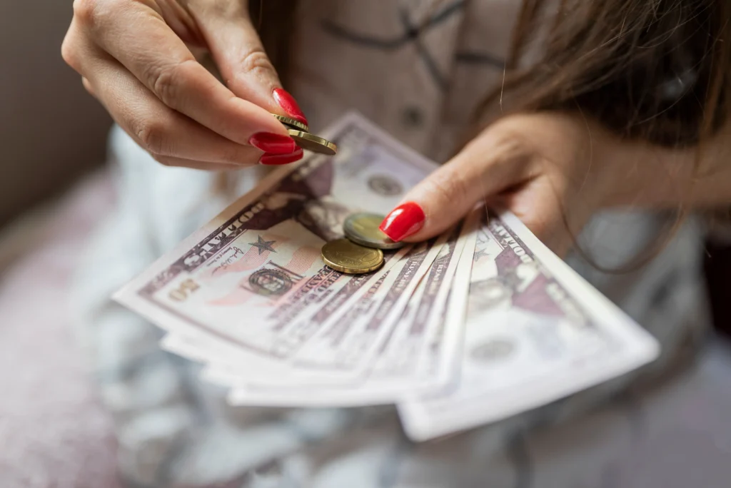 Mujer contando dólares y monedas