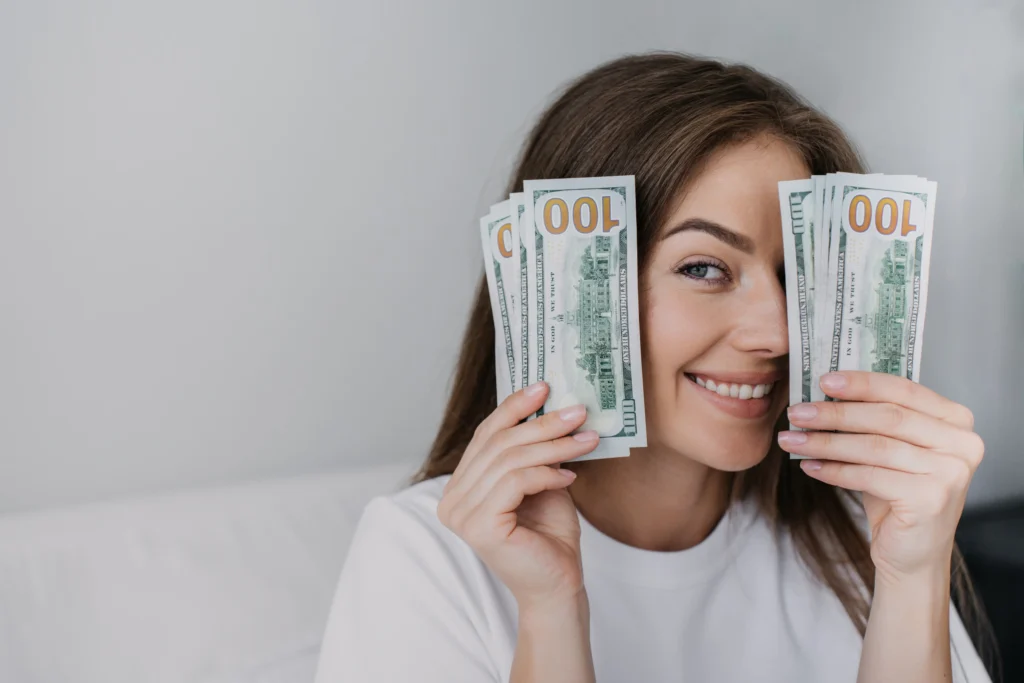 Mujer sosteniendo billetes de cien dólares